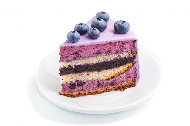 Homemade cake with souffle cream and blueberry jam isolated on white background.