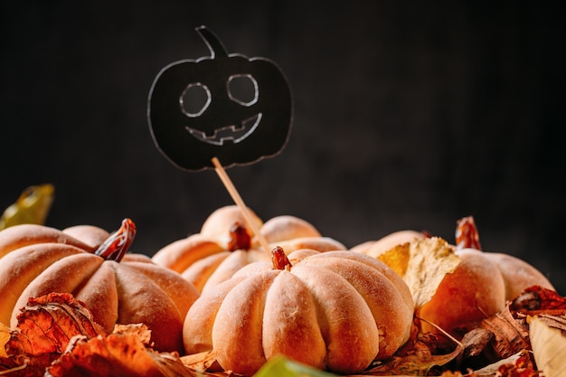 Homemade cakes in the shape of halloween pumpkin with autumn leaves 