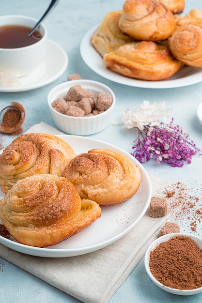 Homemade cakes, snail buns with sugar on a soft blue background.