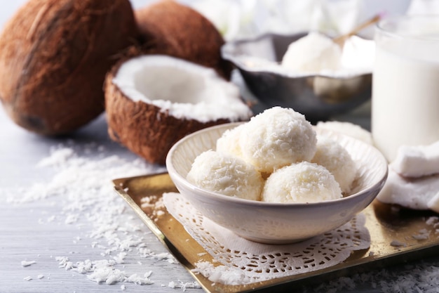 Homemade Candies in coconut flakes and fresh coconut on light background