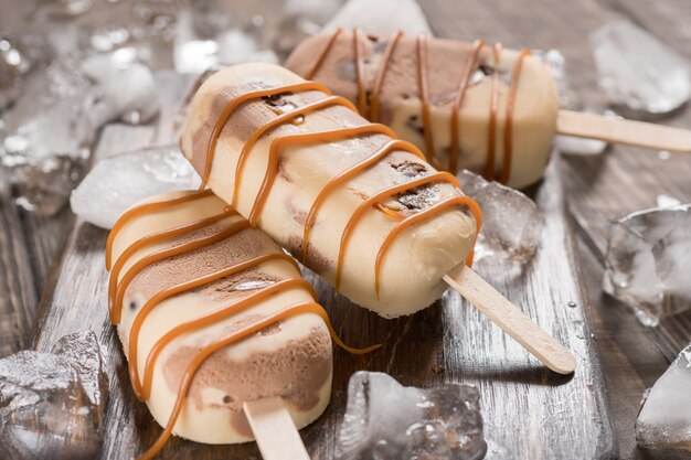 Homemade caramel chocolate popsicles with candy