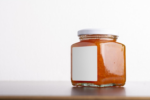 homemade carrot jam in glass jar on a table