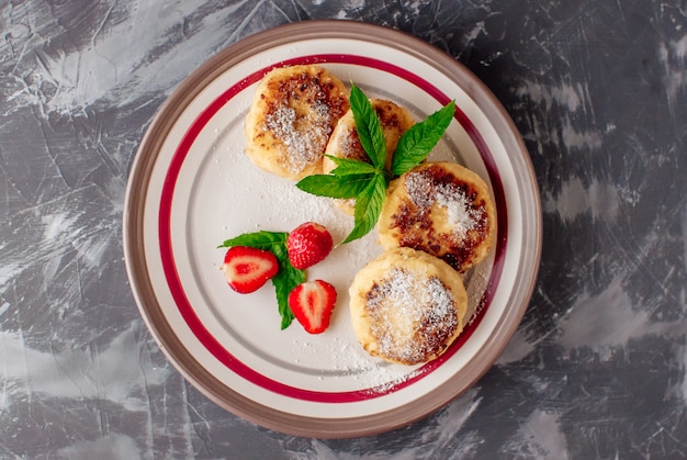 Homemade cheese donuts with berry jam and strawberries