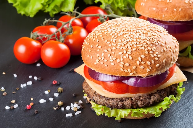 Homemade cheeseburger on black slate surface