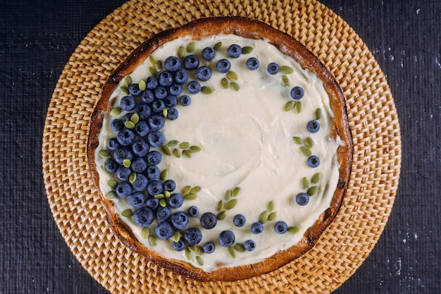 Homemade cheesecake with fresh blueberries and pumpkin seeds