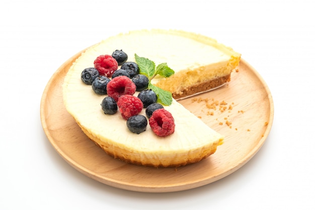 Homemade cheesecake with raspberries and blueberries on white background