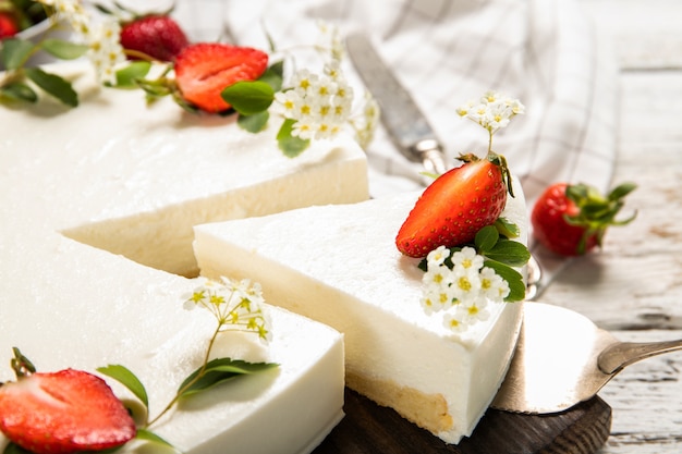 Cheesecake fatta in casa con fragole su uno sfondo di legno. avvicinamento