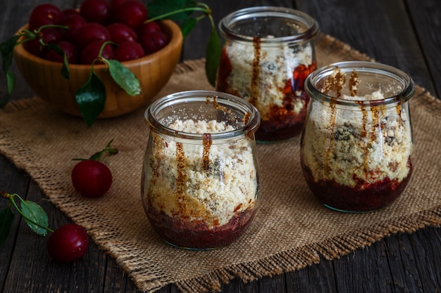 Homemade cherry crumble in glass jars