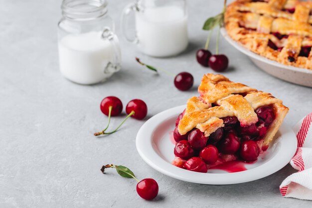 Photo homemade cherry pie with a flaky crust on grey stone background