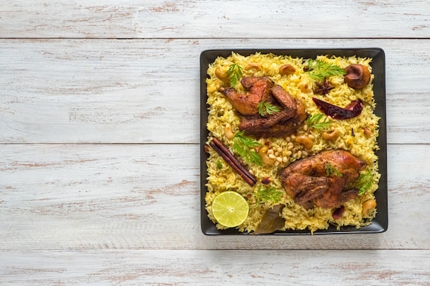 Homemade chicken Biryani. Arabic traditional food bowls Kabsa with meat. Top view