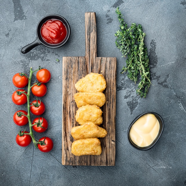 Homemade chicken nuggets fried on grey table, top view.