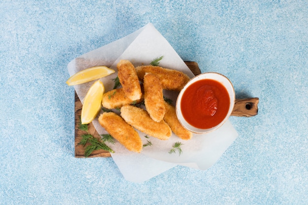 Homemade chicken nuggets on a wooden Board lie on a concrete background.