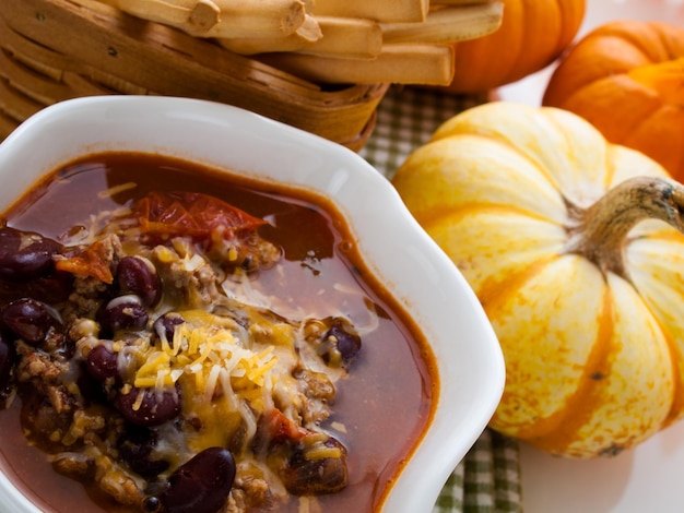 Homemade chili with ground turkey meat in white bowl.