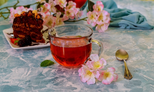 Homemade chocolate brownies and cup of tea on marble background, selective focus