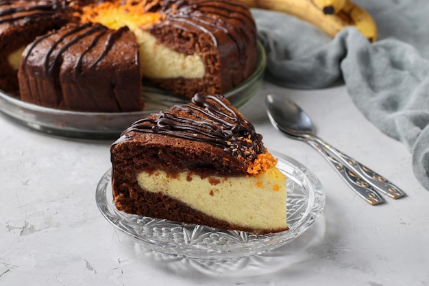 코티지 치즈와 바나나가 전경에서 잘린 케이크 한 조각으로 채워진 홈메이드 초콜릿 케이크