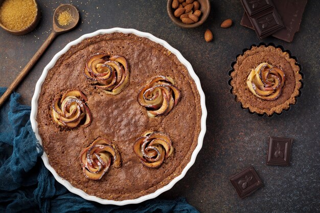 Homemade chocolate cake with frangipane and apple blossoms on a dark concrete