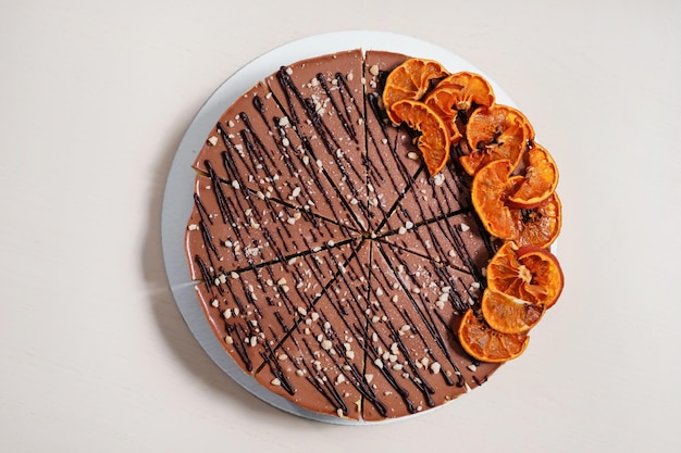 Homemade chocolate cake with nuts and dried oranges on\
parchment paper food delivery homemade baking top view delicious\
tart with chocolate and nuts on the wooden table