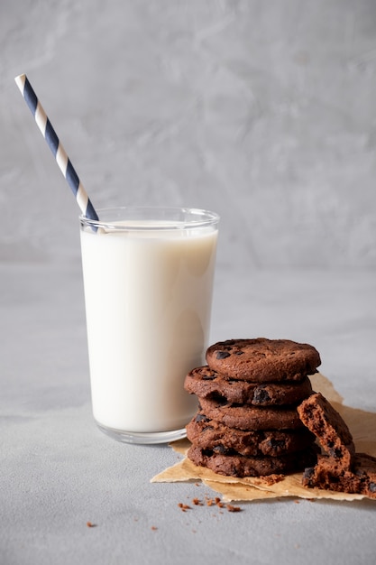 Biscotti al cioccolato fatti in casa e latte di vetro con spazio di copia. su uno sfondo grigio