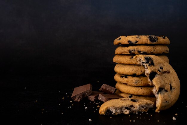 Biscotti fatti in casa con scaglie di cioccolato su una pila isolata su sfondo nero