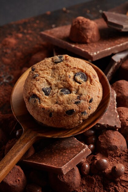 Домашнее шоколадное печенье на деревянной ложке с какао-порошком и конфетами