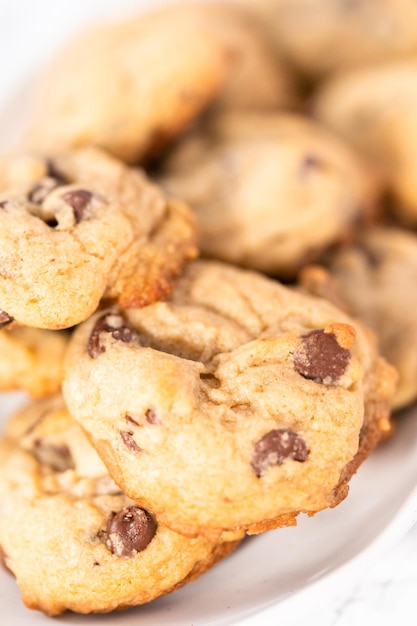 Homemade chocolate chips cookies on a white plate.