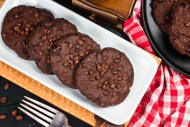 木製のテーブルの背景に自家製のチョコレートクッキー。フードベーキング。