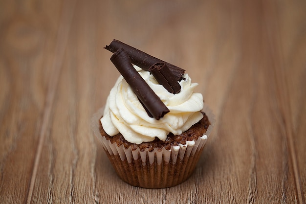 Homemade Chocolate Cupcake with chocolate frosting on wooden table