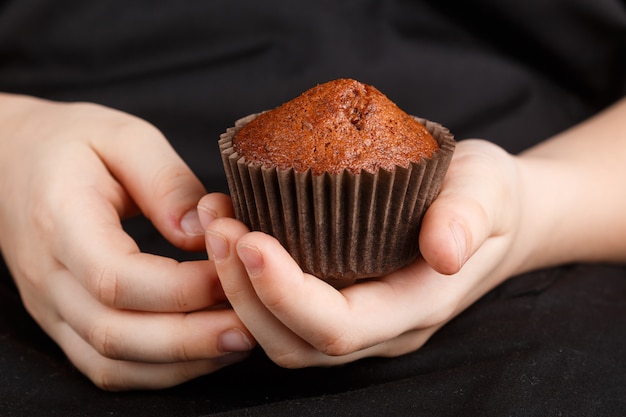 Homemade chocolate muffin in children's hands