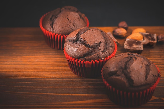 Homemade chocolate muffins or cupcakes on a wooden board