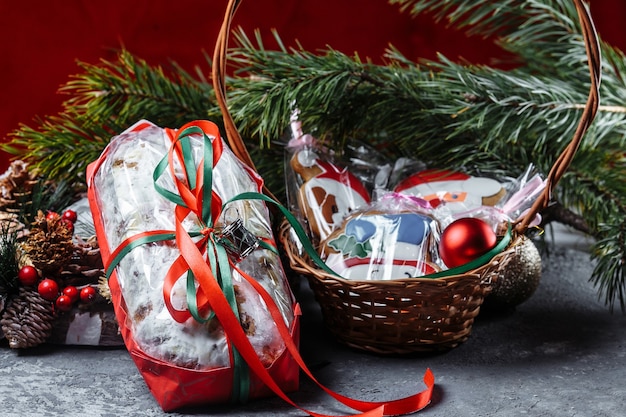 Homemade Christmas cake decorated with gingerbread cookies in a New Year's entourage on a dark background