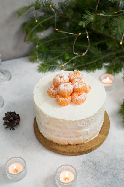 Homemade christmas cake with fir branches candles on gray background