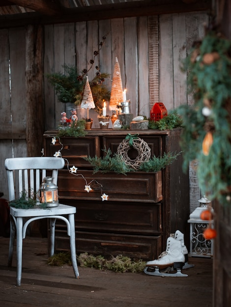 Homemade Christmas decorations on a rustic terrace with a vintage chest of drawers and handmade candlesticks to celebrate Christmas