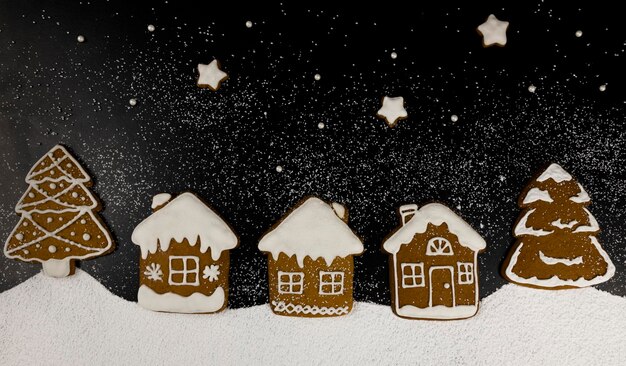 Homemade Christmas gingerbread cookies in the form of houses trees and stars laid out in the style of Christmas Eve