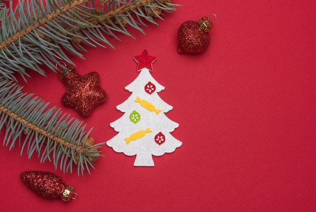 Homemade Christmas tree toy and glass christmas decorations on a red background