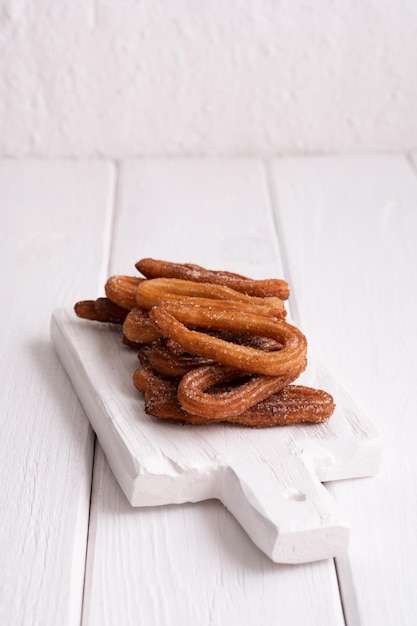 Homemade churros on a white wooden background