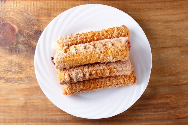 Homemade churros with multiple fillings in a dish on a rustic wooden table