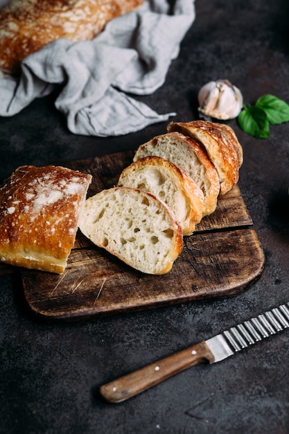 Домашний хлеб чиабатта Ломтики хлеба на деревянной доске Хлеб