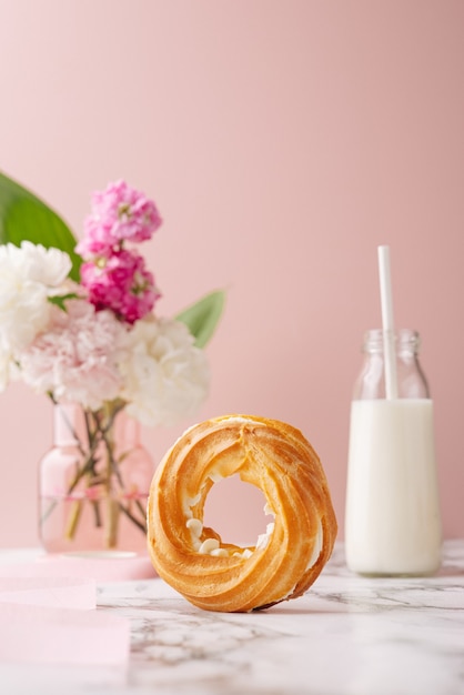 Homemade circle profiterole with custard covered sugar powder on marble table