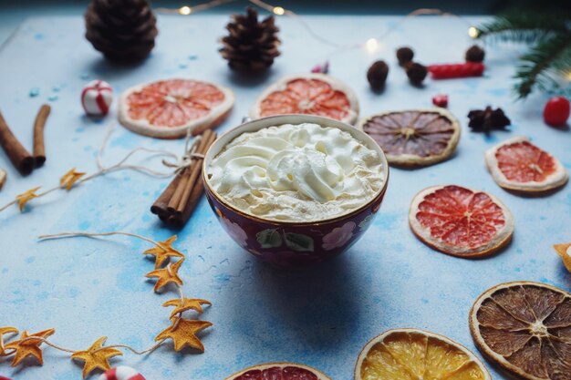 写真 手作りのココアまたはホット チョコレート クリーム ドライ オレンジ モミの木シナモン キャンディー ブルー コンクリート背景クリスマスまたは新年ドリンク居心地の良い家の装飾の選択と集中