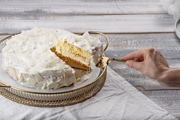 Homemade coconut cake piece of cake on spatula in hand home cooking concept