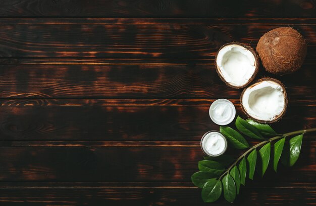 Homemade coconut products on old wooden table. Skin care product with coconut green leaves.