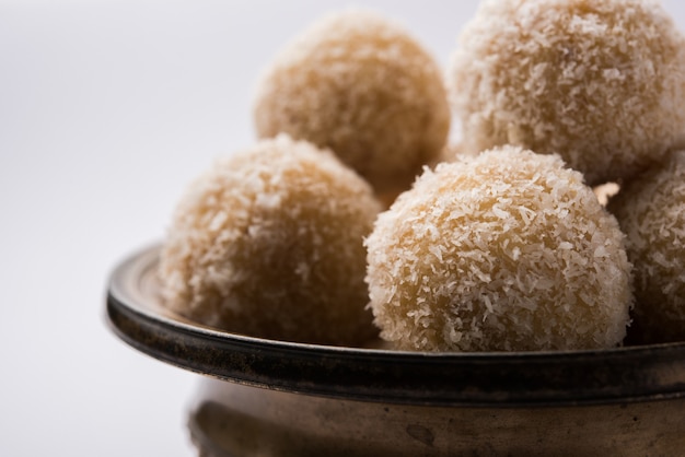 Foto laddoo dolce al cocco fatto in casa o nariyal laddu fatto con latte condensato e zucchero, cibo del festival popolare. servito su sfondo lunatico, messa a fuoco selettiva