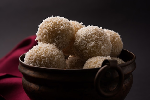 Homemade Coconut Sweet Laddoo OR Nariyal Laddu made with Condensed Milk and Sugar, Popular Festival food. Served over moody background, selective focus