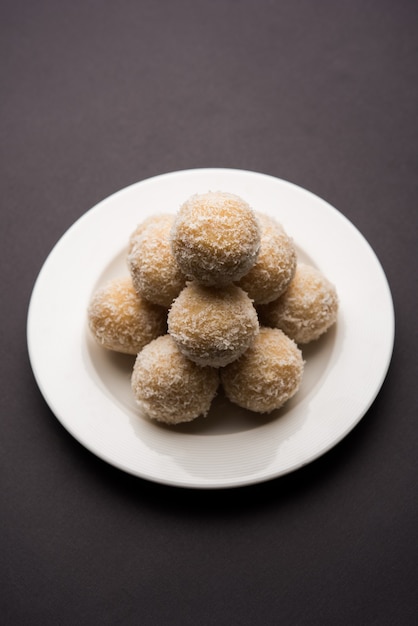 Homemade Coconut Sweet Laddoo OR Nariyal Laddu made with Condensed Milk and Sugar, Popular Festival food. Served over moody background, selective focus