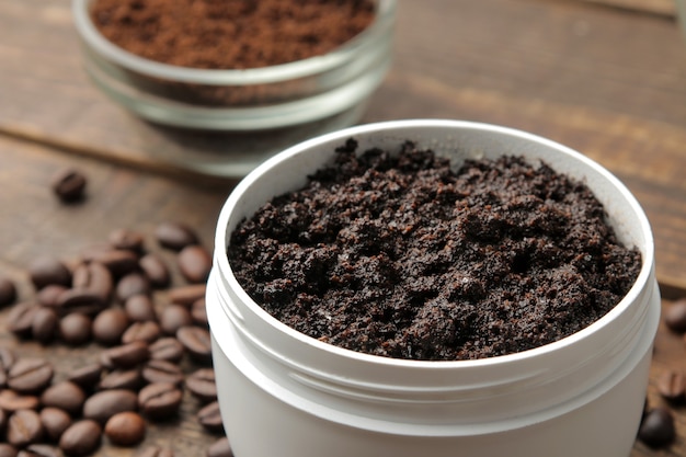 Homemade coffee scrub in a white jar for the face and body and various ingredients for making scrub.