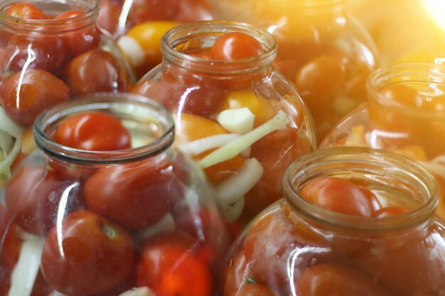 Homemade conservering grote glazen pot met rode rijpe ingelegde tomaten augurken voor de winter