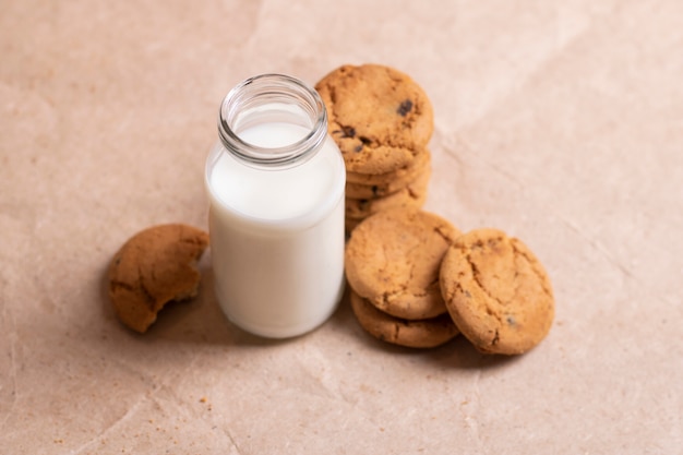Homemade cookies and bottle of milk on table close up