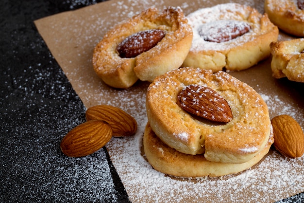 Homemade cookies with almonds on a dark background.