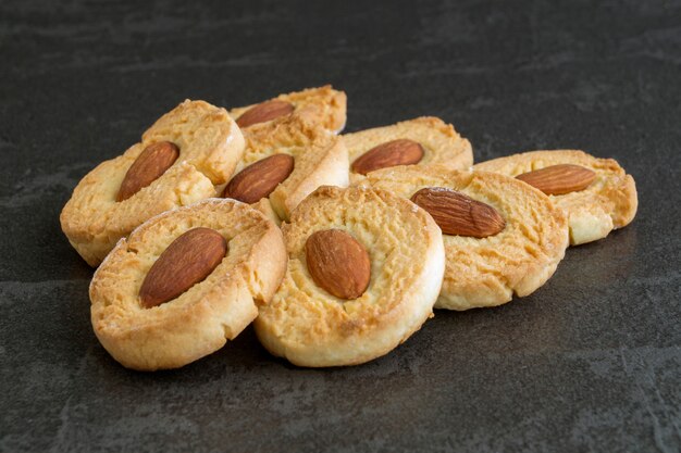 Homemade cookies with almonds on a dark background.