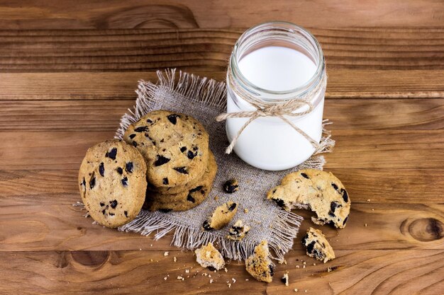 Homemade cookies with a bottle of milk on a wooden table